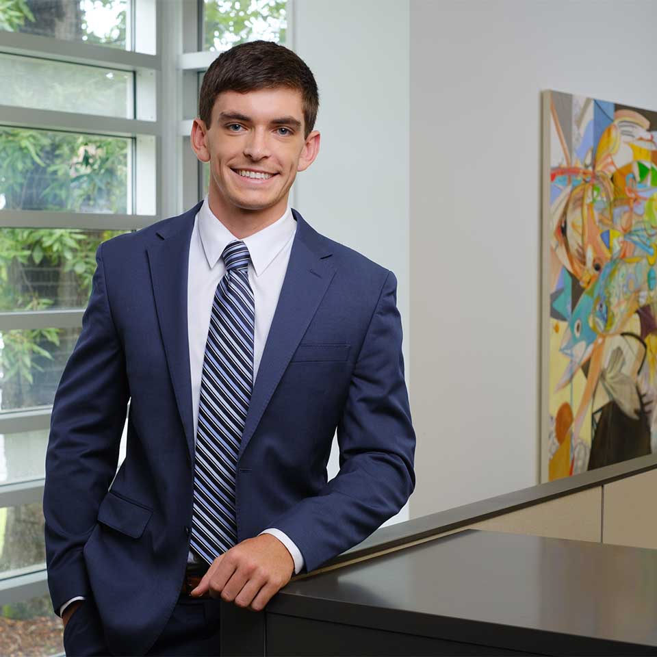 Michael B. Holt standing in front of paneled windows and an abstract painting.